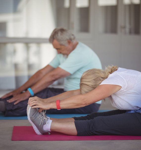 Senior,Couple,Performing,Stretching,Exercise,At,Home